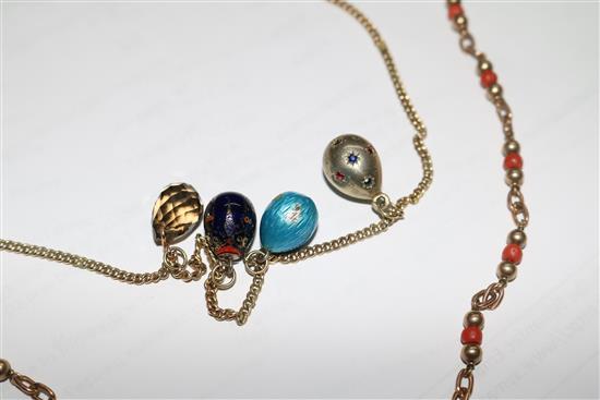 A 9ct gold necklace hung with four egg shaped charms and a 9ct gold and coral bead necklace.